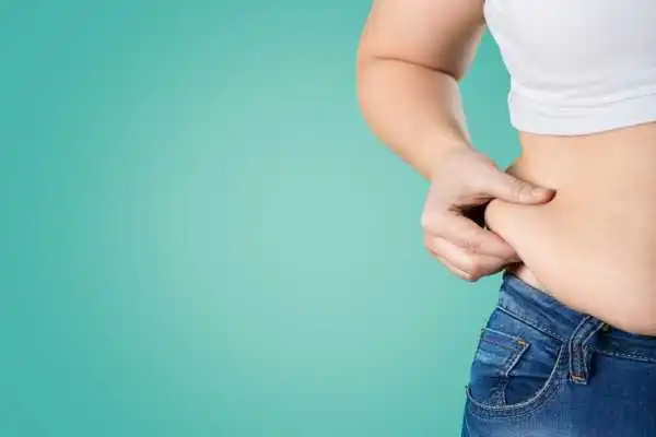Image of woman pinching her love handles to show weight gain Herefordshire
